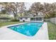 Inviting rectangular swimming pool with a screened enclosure in a fenced backyard at 308 Wade Ave, Deland, FL 32724
