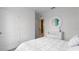 Bedroom with white bedding, decorative mirror, and access to another room at 316 Corso Loop, Winter Haven, FL 33884
