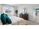 Main bedroom with king-size bed, teal pillows, dresser, and view to dining room at 316 Corso Loop, Winter Haven, FL 33884