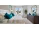 Main bedroom with king-size bed, teal pillows, and a view to backyard at 316 Corso Loop, Winter Haven, FL 33884