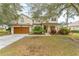 Two-story house with brown garage door, landscaping, and a spacious front yard at 3689 Rolling Hills Ln, Apopka, FL 32712