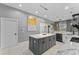 Contemporary kitchen showcasing a central island with marble countertops, modern lighting, and sleek appliances at 3689 Rolling Hills Ln, Apopka, FL 32712