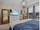 Primary bedroom with dresser, large TV and comfy bedding at 385 Alcove Dr, Groveland, FL 34736