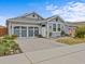 Gray craftsman style home with a three-car garage and landscaped front yard at 385 Alcove Dr, Groveland, FL 34736