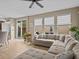 Bright Gathering room with an L-shaped sofa and sliding glass doors leading to the backyard at 385 Alcove Dr, Groveland, FL 34736