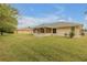 Large backyard with grassy area and view of house at 4572 Woodcove Dr, Port Orange, FL 32127