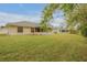 House with large grassy backyard and trees at 4572 Woodcove Dr, Port Orange, FL 32127