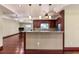 Open kitchen featuring granite countertops, stainless appliances, and wooden cabinets and floors at 4914 Gran Lac Ave, Belle Isle, FL 32812