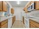 Galley kitchen with oak cabinets and white appliances at 588 Brantley Terrace Way # 303, Altamonte Springs, FL 32714