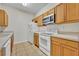 Kitchen with oak cabinets, white appliances, and tile floor at 588 Brantley Terrace Way # 303, Altamonte Springs, FL 32714