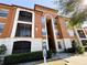 Exterior view of a Spanish-style apartment building with landscaping at 6149 Metrowest Blvd # 106, Orlando, FL 32835