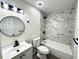 Modern bathroom featuring marble-style tile, matte black fixtures, and a round mirror at 630 Sailfish Rd, Winter Springs, FL 32708