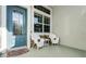Welcoming front porch with teal door and wicker chairs at 7836 Crosswinds Way, Mount Dora, FL 32757