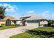House exterior with a two-car garage and manicured lawn at 7836 Crosswinds Way, Mount Dora, FL 32757