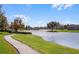Serene walking path alongside a sparkling lake at 7836 Crosswinds Way, Mount Dora, FL 32757