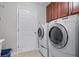 Laundry room with washer, dryer, and built-in cabinets at 7836 Crosswinds Way, Mount Dora, FL 32757