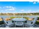 White wicker patio furniture overlooking a peaceful lake at 7836 Crosswinds Way, Mount Dora, FL 32757