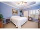 Spacious bedroom with light blue walls, a ceiling fan, and large windows at 8773 Silk Bay Pl, Orlando, FL 32827