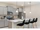 Modern kitchen with gray cabinets, quartz countertops and island with seating at 8906 Zurich Ln, Kissimmee, FL 34747