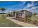 One story home with gray siding, stone accents, and palm tree at 9154 Harris Hawk Dr, Leesburg, FL 34788