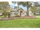 Single-story home with red door, landscaped yard, and stone wall at 926 Palm Oak Dr, Apopka, FL 32712