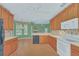 Eat-in kitchen boasts wood cabinets, white appliances & pool view at 926 Palm Oak Dr, Apopka, FL 32712