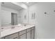 Modern bathroom with double vanity and a large mirror at 1046 Splash Shot Pl, Davenport, FL 33896