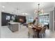 Open concept dining area with modern light fixture and seating for six at 1046 Splash Shot Pl, Davenport, FL 33896