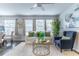 Bright living room with a white sofa, blue chair, hardwood floors and natural light at 1057 S Hiawassee Rd # 1911, Orlando, FL 32835
