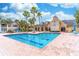 Community pool with crystal clear blue water surrounded by palm trees and ample lounge seating at 1057 S Hiawassee Rd # 1911, Orlando, FL 32835