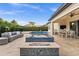This backyard features a gorgeous pool, jacuzzi, fire pit, and outdoor dining area at 10824 Royal Cypress Way, Orlando, FL 32836