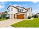 Beautiful two-story home with a tile roof, paver driveway, and a well-manicured lawn at 10824 Royal Cypress Way, Orlando, FL 32836