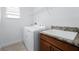 Well-lit laundry room with utility sink and granite counters, washer and dryer at 10824 Royal Cypress Way, Orlando, FL 32836