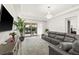 Spacious living room with a plush gray sectional sofa, a view of the pool area, and modern decor at 10824 Royal Cypress Way, Orlando, FL 32836