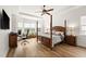 Serene main bedroom featuring hardwood floors, a four-poster bed, and a bay window at 10824 Royal Cypress Way, Orlando, FL 32836