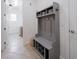 Mudroom with gray hall tree featuring a bench, hooks, and shelving for organization at 10824 Royal Cypress Way, Orlando, FL 32836