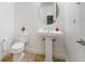 Cozy powder room featuring a pedestal sink, round mirror, and tiled floors at 10824 Royal Cypress Way, Orlando, FL 32836