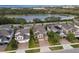 Aerial view of a neighborhood with well-maintained lawns and a scenic lake in the background at 1416 Cabot Dr, Clermont, FL 34711