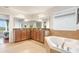 Spacious bathroom featuring double vanity, soaking tub, tiled floor, and neutral walls at 1416 Cabot Dr, Clermont, FL 34711