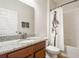 Bathroom features a granite countertop, wood vanity, and shower with decorative curtain at 1416 Cabot Dr, Clermont, FL 34711
