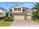 Charming two-story home featuring a three-car garage, neutral stucco, stone accents and a brick paver driveway at 1416 Cabot Dr, Clermont, FL 34711