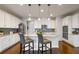Bright kitchen with a granite island, stainless steel appliances, a mosaic backsplash, and pendant lighting for a modern touch at 1416 Cabot Dr, Clermont, FL 34711