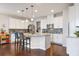 Modern kitchen featuring a central island with bar seating, white cabinets, granite countertops, and stainless steel appliances at 1416 Cabot Dr, Clermont, FL 34711