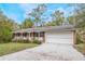 Brick ranch house with carport, front porch, and mature landscaping at 15941 Sw 8Th Pl, Ocala, FL 34481