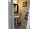 Small half bathroom with pedestal sink and dark mirror at 16307 Old Ash Loop, Orlando, FL 32828