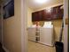 Laundry room with washer, dryer, and dark wood cabinets at 16307 Old Ash Loop, Orlando, FL 32828