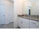 Bathroom with granite countertop, white cabinets, and tile floor at 16626 Point Rock Dr, Winter Garden, FL 34787
