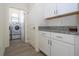 Bright laundry room with white cabinets, granite countertop, and washer/dryer at 16626 Point Rock Dr, Winter Garden, FL 34787