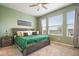 Spacious bedroom with a large green comforter and ceiling fan at 17524 Promenade Dr, Clermont, FL 34711