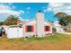 Side view of a tan house with red shutters and a white fence at 1806 Crownwood Dr, Orlando, FL 32810